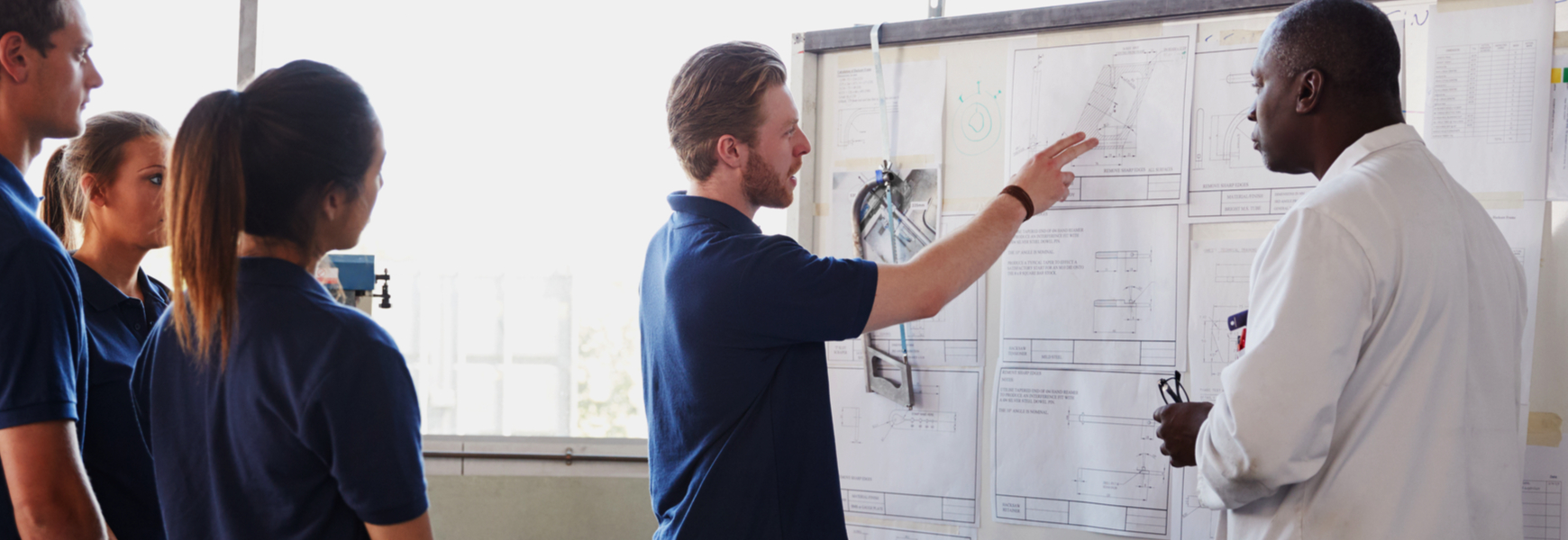 engineers discussing in front of whiteboard