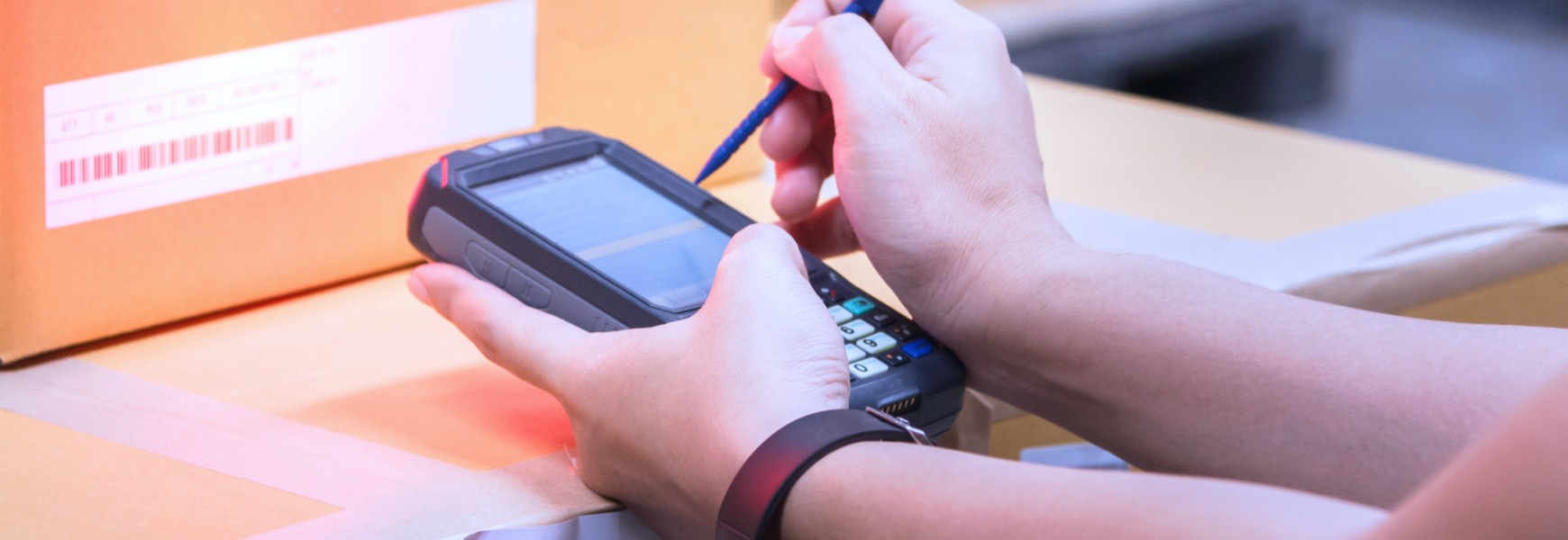factory worker scanning barcode on box using electronic device