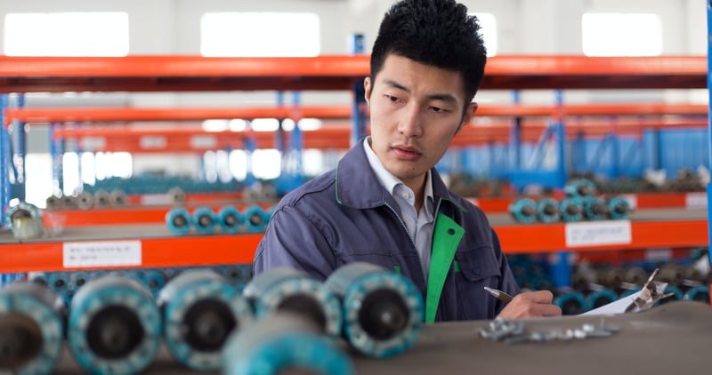 Factory manager checking quality of parts