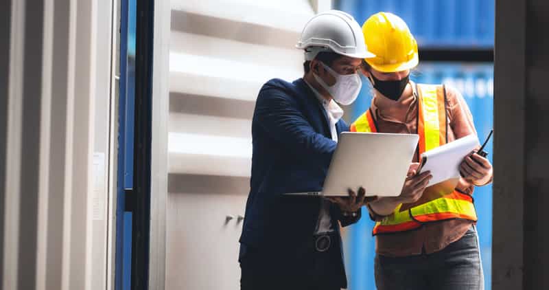 Factory executive and engineer inspecting warehouse