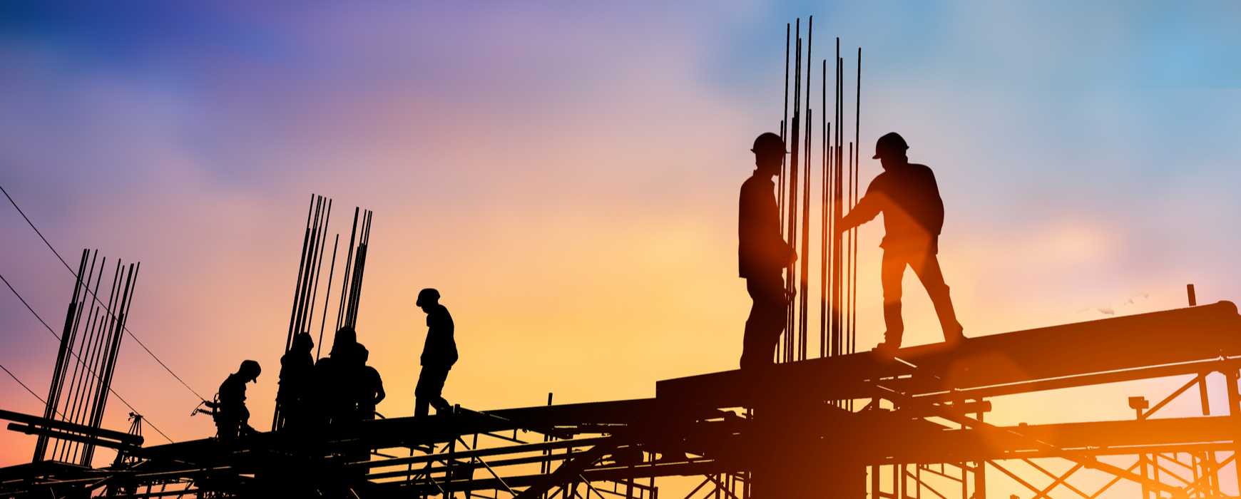 Silhouette of construction crew working on foundations of a building