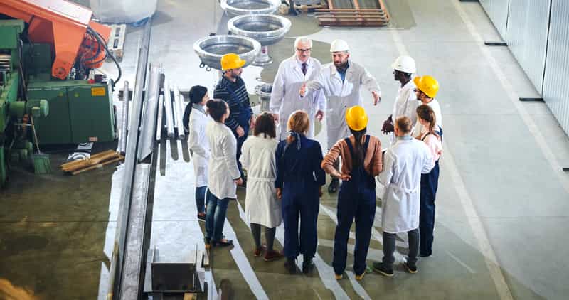 Factory workers meeting with management in industrial workshop