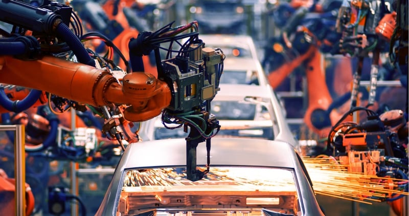 machine arm working on car in factory