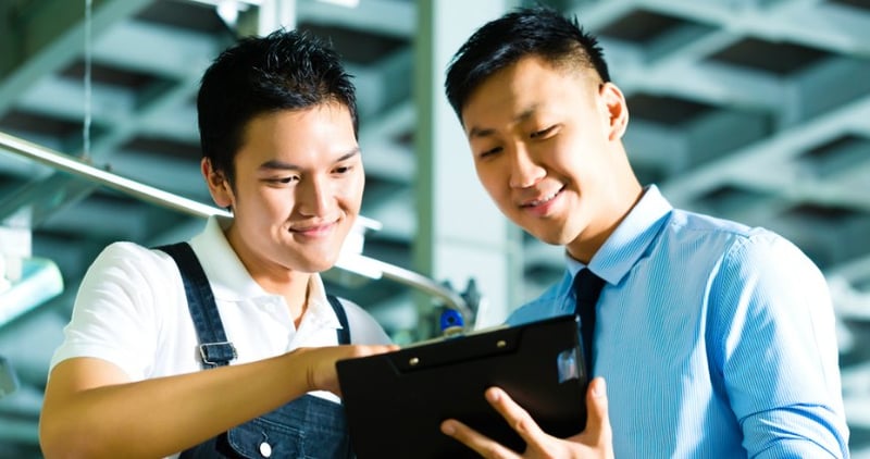 Two men looking at a tablet device