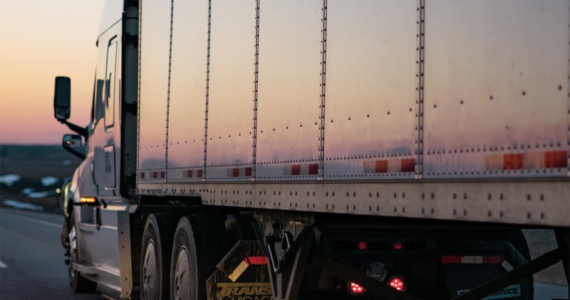 a lorry driving on the road in sunset