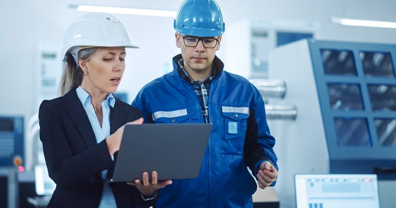 Man and woman checking laptop in factory