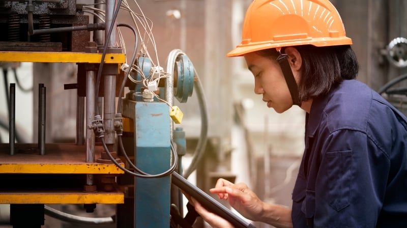 Woman working on factory equipment