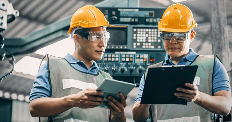 factory workers looking at ipad