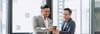 A businessman sharing information on his phone with a colleague