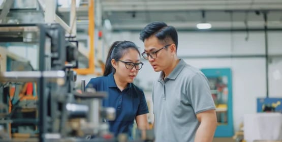 two factory workers working in a factory