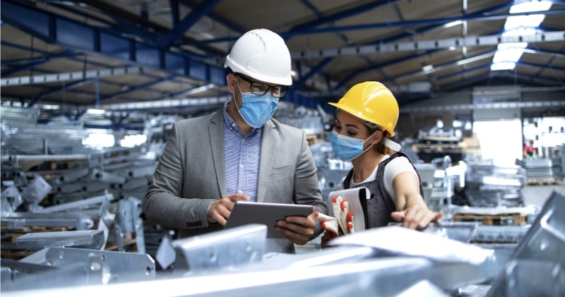 man and woman working together inside a factory