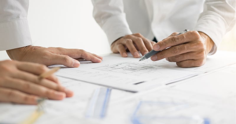 Man pointing pen at paper/design