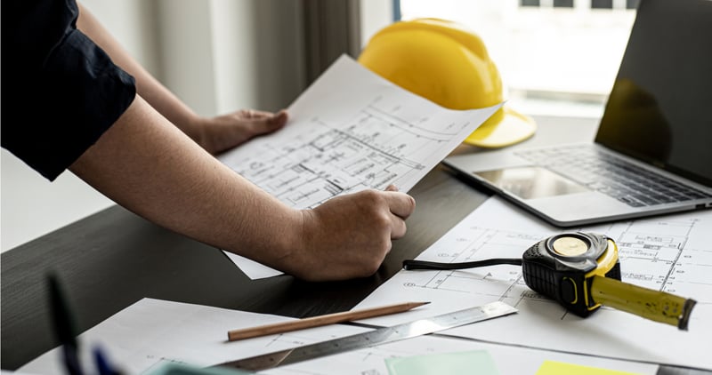 An engineer reviewing blueprints of his factory